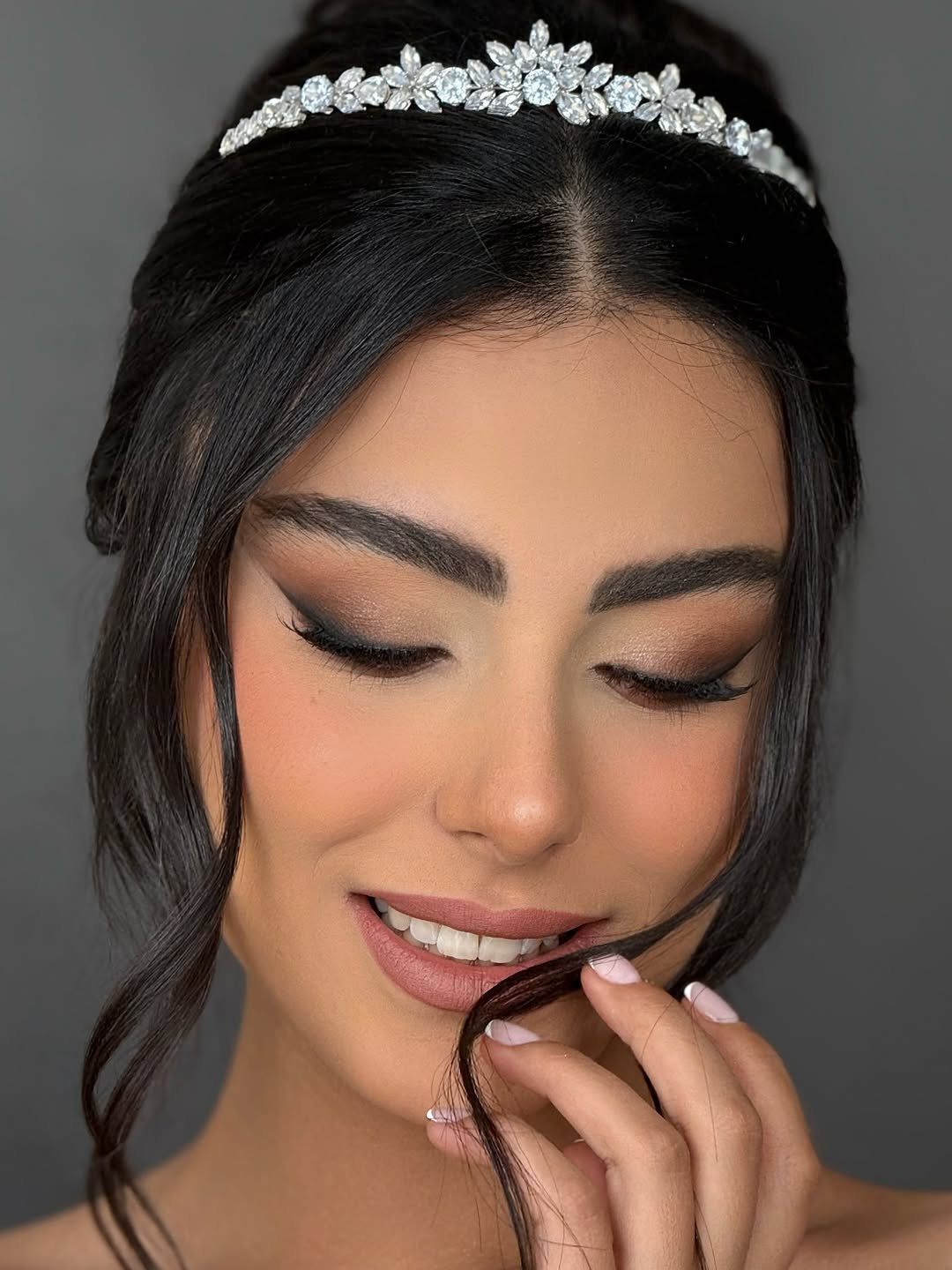 Bridal makeup Dubai look on a real bride with soft smokey eyes, nude lips and a crystal tiara