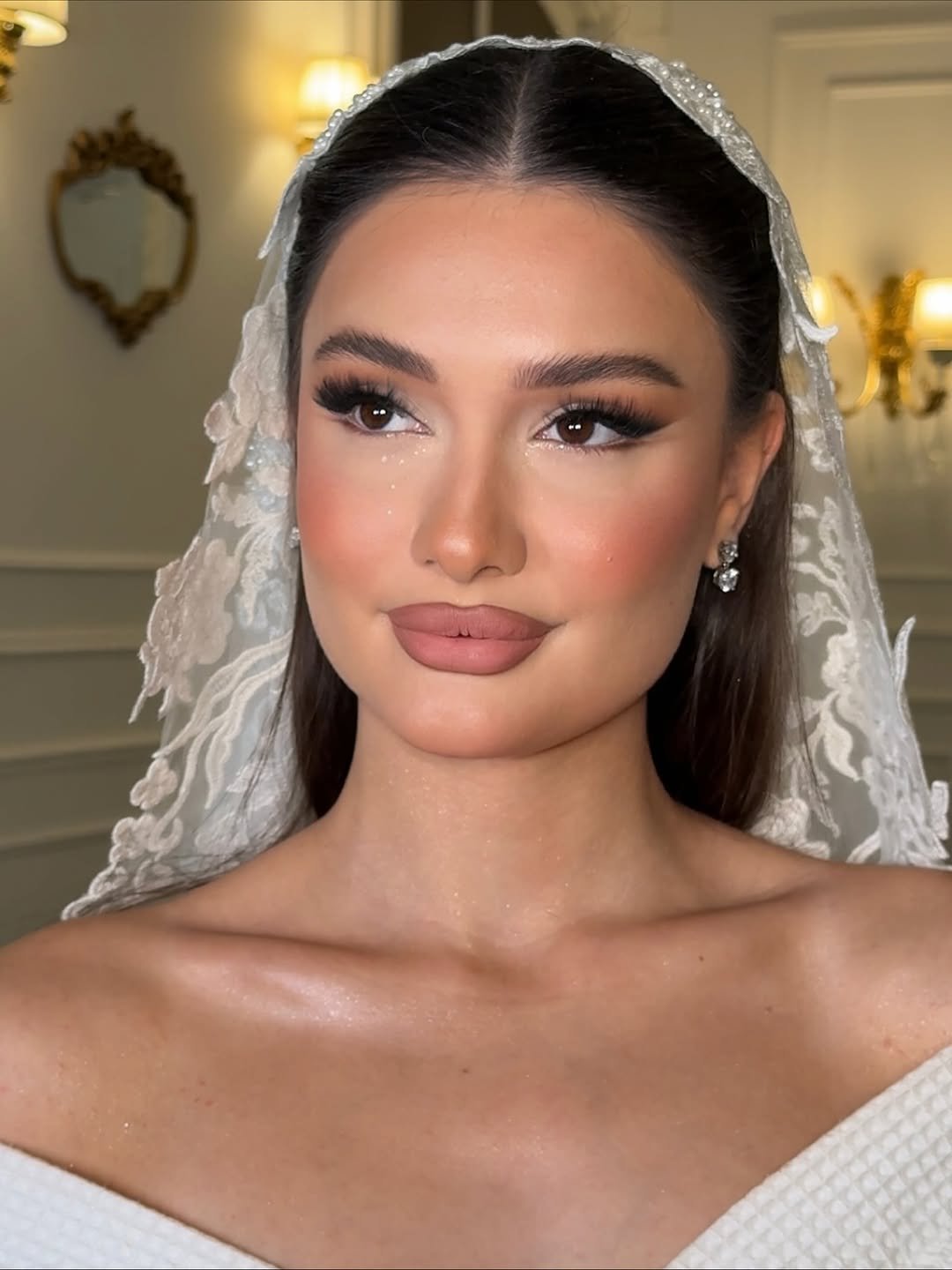 Western bridal look with soft lashes, sculpted skin, nude lips and a lace wedding veil